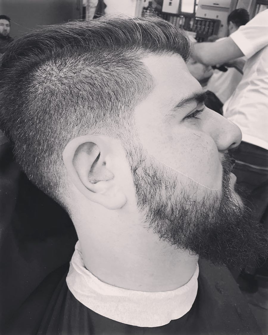 Zwart-witfoto van een fade met een volle baard