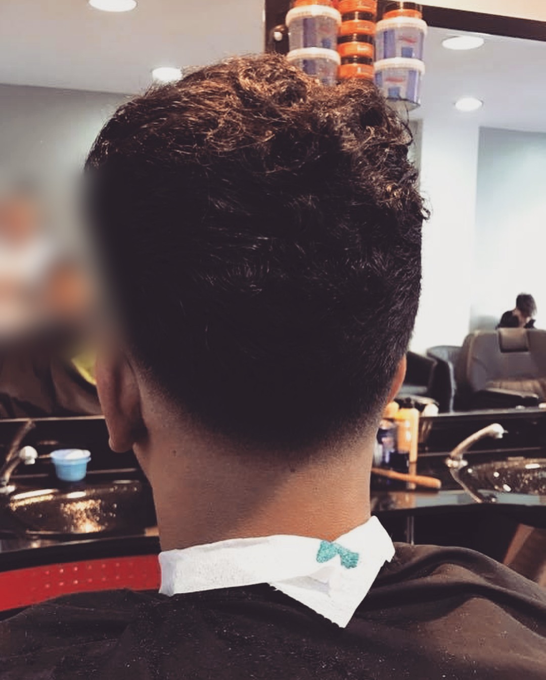 Achterhoofd van een klant na het knippen: een nette fade in de nek, in de zaak